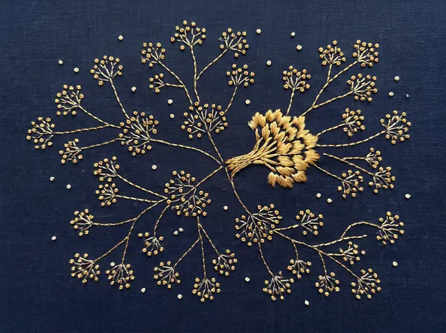 An embroidered constellation on navy cloth: gold knots joined by fine gold stitches into branching clusters, one of them stitched brighter than the rest.