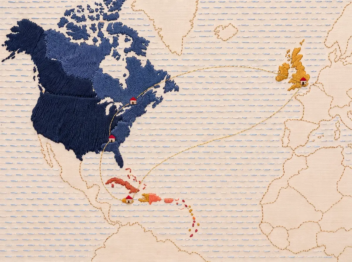 An embroidered map of the North Atlantic, with gold threads stitched from Jamaica up to Atlanta and Toronto and across the ocean to London, and a tiny house at each place.
